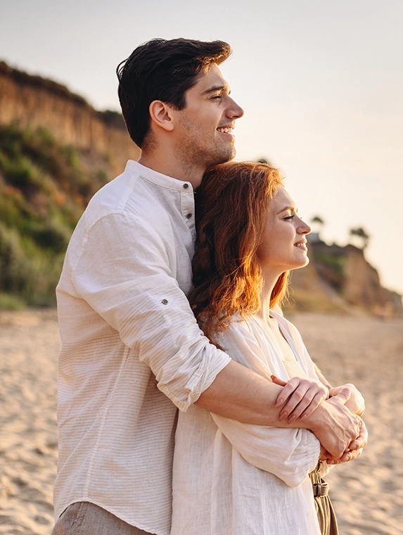 Young couple enjoying the beach with improved vision thanks to LASIK eye surgery in Los Angeles, California